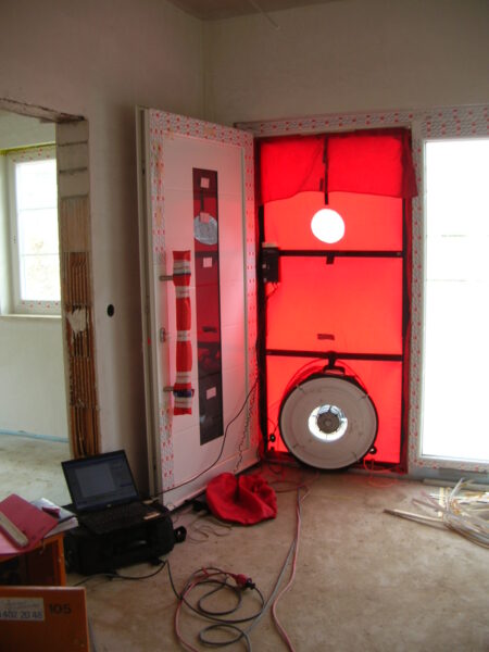 Rote Blower Door in Tür auf Baustelle